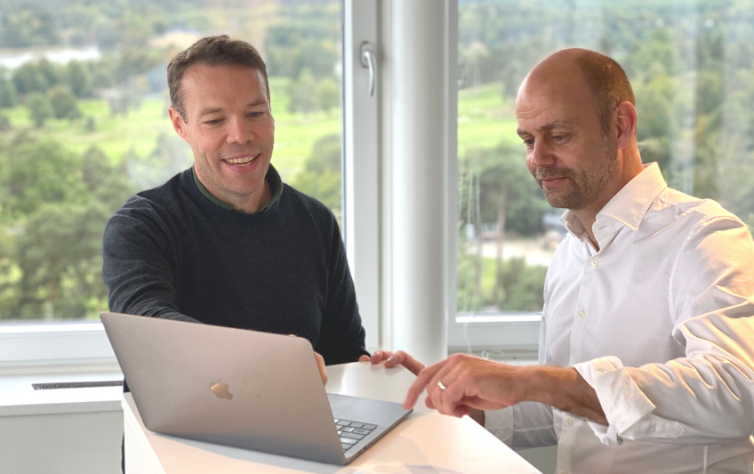 Zwei Männer, Gründer der Online-Prüfungsplattform Exam.net, schauen auf einen Laptop-Bildschirm